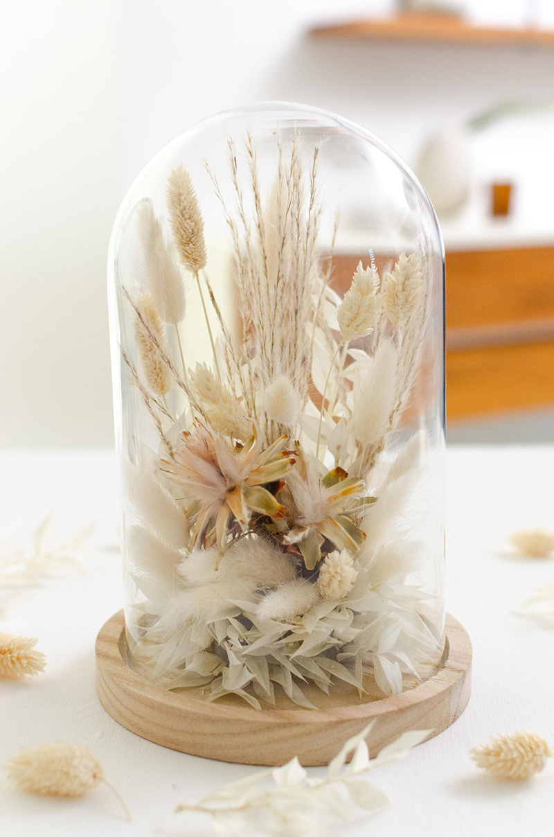 Cloche de fleurs séchées aux tons blancs